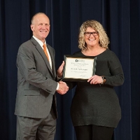 Doctor Potteiger posing for a photo with an award recipient in a grey sweater dress